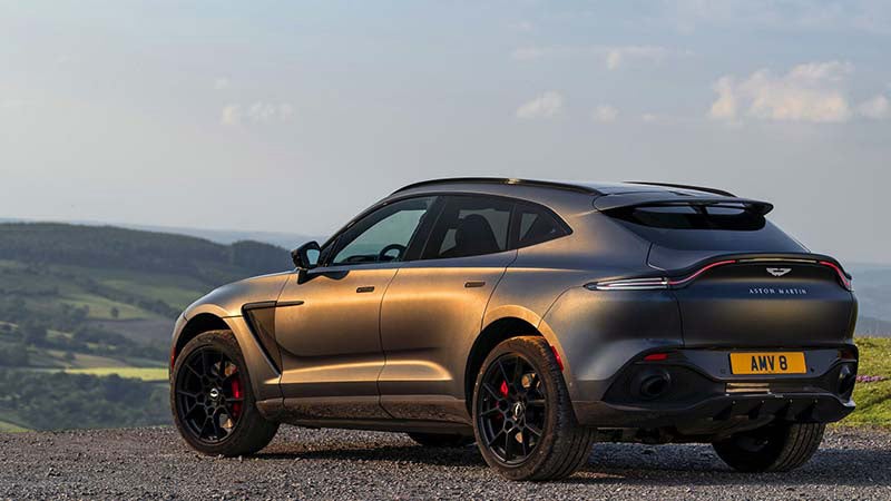 Aston Martin DBX rear view over looking a rustic country side